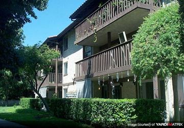 Pico Rivera apartment for rent - A building with a balcony and a hedge in front.