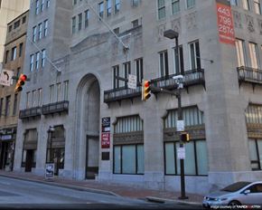 Baltimore apartment for rent - a traffic light in front of a building on a city street