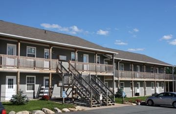 Kentville apartment for rent - A building with a wooden staircase leading to the second floor.