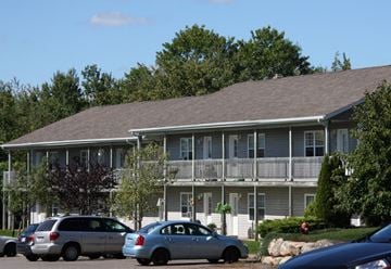 Kentville apartment for rent - A silver minivan is parked in front of a two-story house.