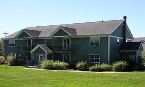 Kentville apartment for rent - A green house with a brown roof and a chimney.