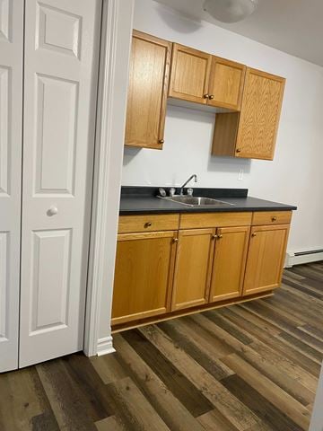 Kentville apartment for rent - A kitchen with wooden cabinets and a black countertop.