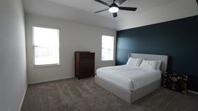 Royse City house for rent - A bedroom with a bed, dresser, and ceiling fan.