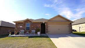Royse City house for rent - A house with a brown roof and a garage door.