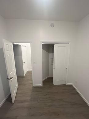 St. Louis apartment for rent - A room with white walls and a wooden floor with two open doors.