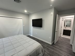 Pompano Beach apartment for rent - A bedroom with a bed, a television, and a closet.