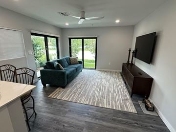 Pompano Beach apartment for rent - A living room with a green couch and a television on the wall.
