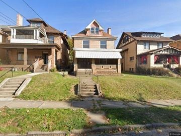 Pittsburgh apartment for rent - A row of houses with a green lawn in front.