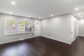 Gary house for rent - A spacious room with wooden floors and white walls.