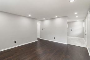 Gary house for rent - A large empty room with wooden floors and white walls.