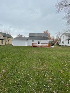Elida house for rent - A white house with a grey roof is surrounded by a grassy field.