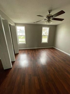 Elida house for rent - A room with a ceiling fan and wood flooring.
