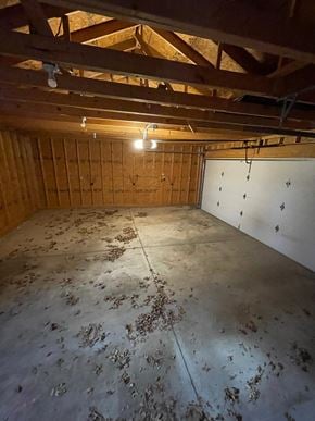 Elida house for rent - A room with wooden walls and ceiling, and a concrete floor with debris scattered across it.