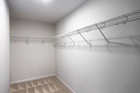 Durham house for rent - A white closet with a carpeted floor and a metal rack.