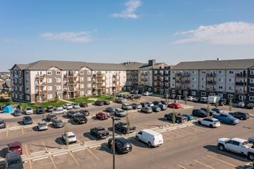 Red Deer apartment for rent - A parking lot with cars and apartment buildings in the background.