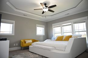 Garner house for rent - A bedroom with a white bed and yellow accent chair.