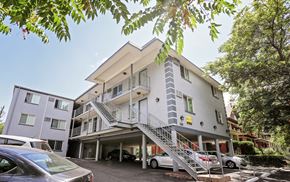 Denver apartment for rent - a white apartment building with stairs and cars parked in front of it