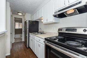 Denver apartment for rent - a kitchen with white cabinets and a stove and a refrigerator