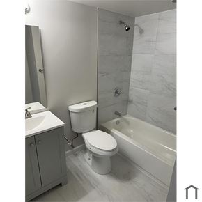 Washington apartment for rent - A white toilet sits next to a bathtub in a bathroom.