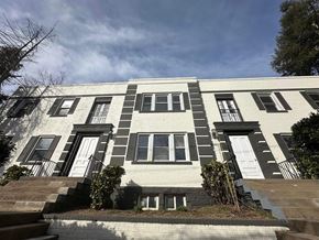 Washington apartment for rent - A white building with black shutters and a black door.