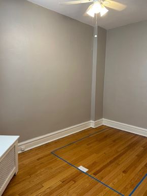 Oak Park apartment for rent - A room with a ceiling fan and a wooden floor.