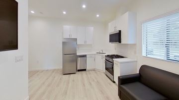 Los Angeles apartment for rent - A modern kitchen with a stainless steel refrigerator and a black couch.