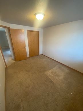 Moorhead apartment for rent - A room with a carpeted floor and two doors.