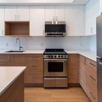 Victoria apartment for rent - A modern kitchen with a stainless steel oven and wooden cabinets.