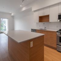 Victoria apartment for rent - A modern kitchen with a wooden island and stainless steel appliances.