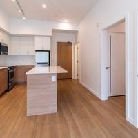 Victoria apartment for rent - A kitchen with a white counter top and wooden floors.