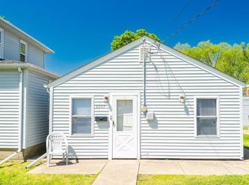 Peoria Heights house for rent - A small house with a white door and a white chair in front of it.