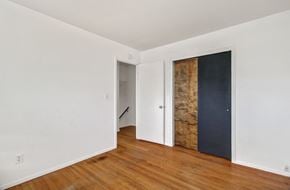 Colorado Springs house for rent - A room with a wooden floor and white walls.
