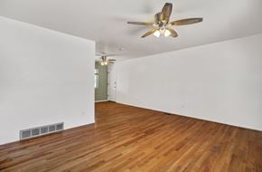 Colorado Springs house for rent - A room with a ceiling fan and wooden flooring.