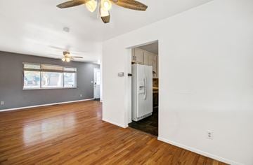 Colorado Springs house for rent - A room with a ceiling fan and a refrigerator in the kitchen area.