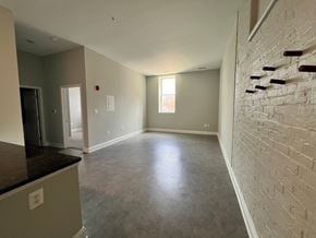 Baltimore apartment for rent - A room with a white brick wall and a window.