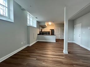 Baltimore apartment for rent - A spacious kitchen with a bar counter and a refrigerator is visible.