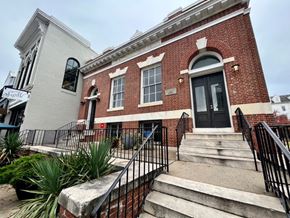 Baltimore apartment for rent - A red brick building with a black door and windows.