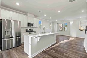 Apex house for rent - A modern kitchen with stainless steel appliances and wooden flooring.