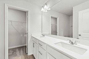 Apex house for rent - A white bathroom with a sink, mirror, and a shower with a glass door.