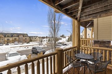 Eden house for rent - A wooden deck with a table and chairs overlooking a snowy street.