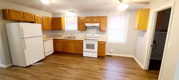Clarksville house for rent - A kitchen with wooden cabinets and a white refrigerator.