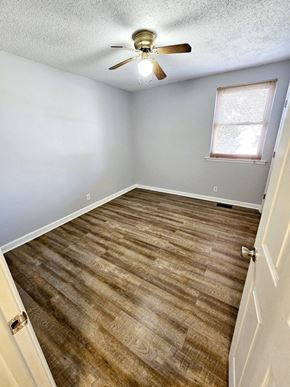 Clarksville house for rent - A room with a ceiling fan and wooden flooring.