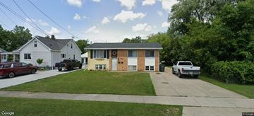 Depew apartment for rent - A house with a white garage door and a brown garage door.