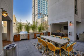 Oakland apartment for rent - A patio with a table and chairs.is surrounded by buildings.