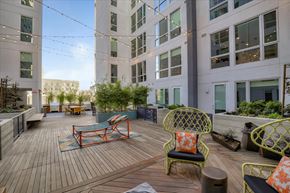 Oakland apartment for rent - A patio with a table and chairs. is surrounded by buildings.
