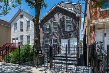 Chicago apartment for rent - A black iron gate blocks the entrance to a brick house.
