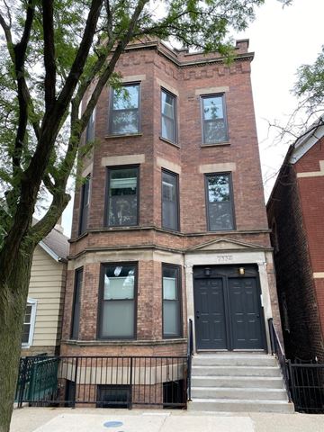 Chicago apartment for rent - A brick building with a black door and windows.