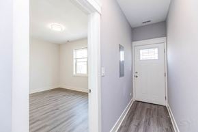 Chicago apartment for rent - A white door is in a room with wood flooring.