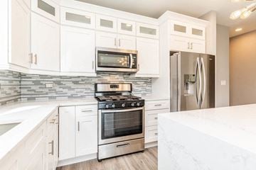 Chicago apartment for rent - A modern kitchen with white cabinets and stainless steel appliances.