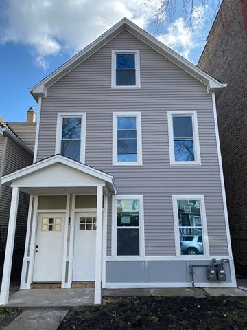 Chicago apartment for rent - A grey house with a white door and windows.